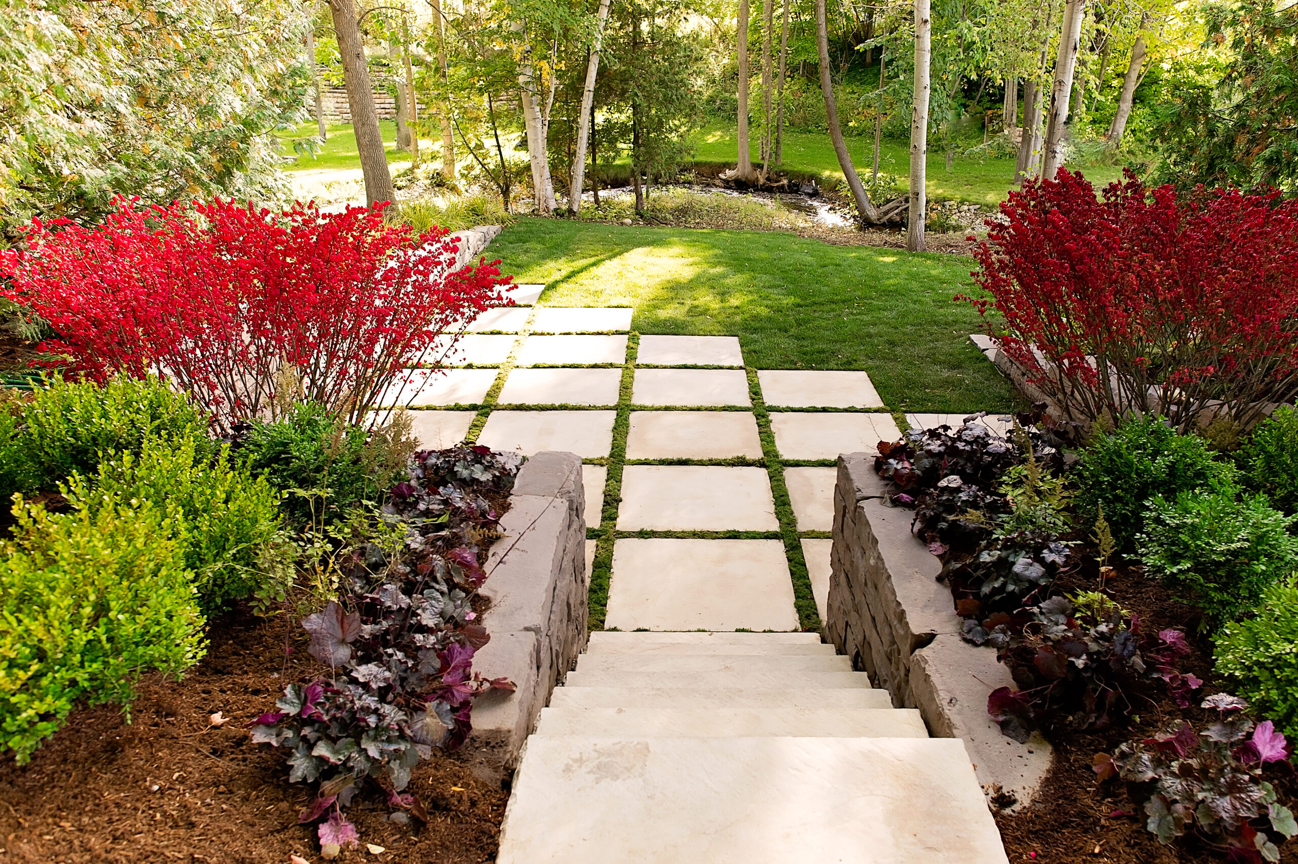 Create a seamless transition between your hardscapes and nature using Miros slabs. Other products shown: Dimensional Steps and Kodah Walls